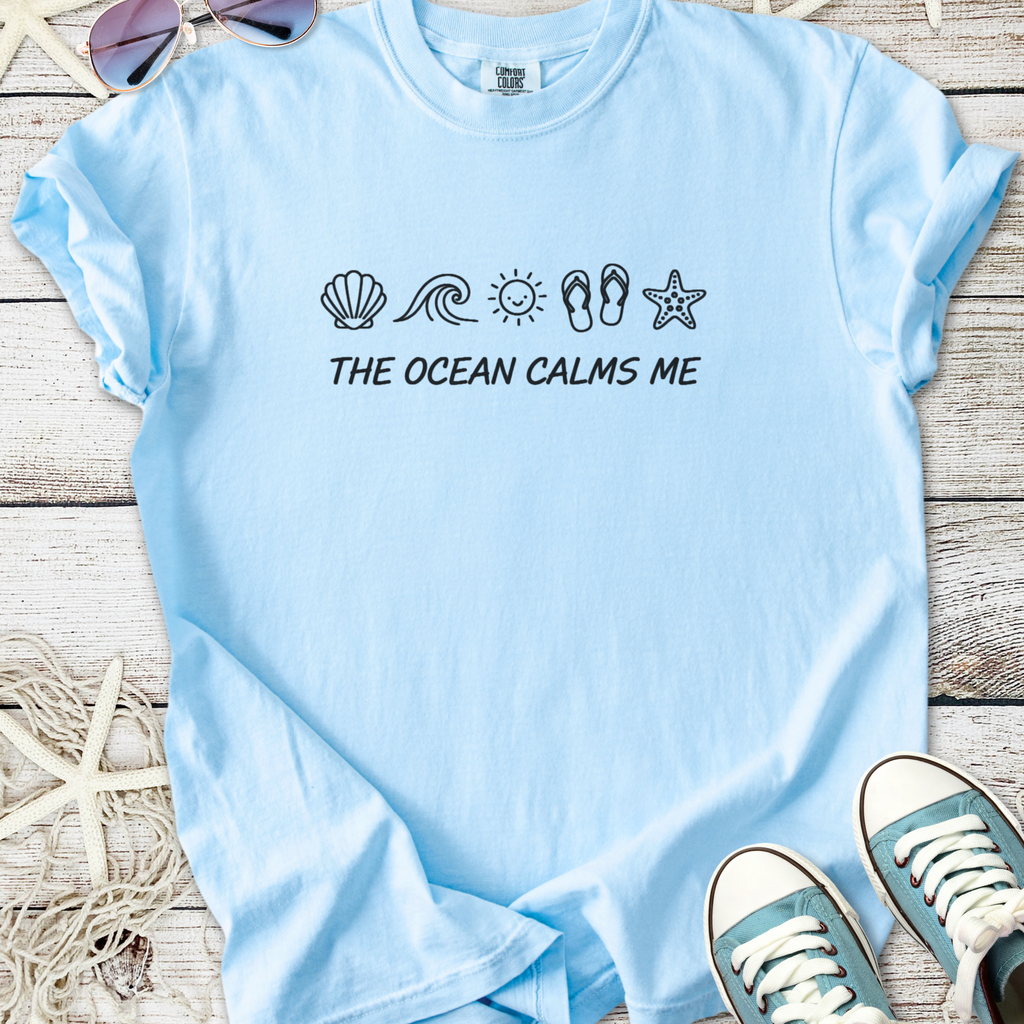 Light blue cotton t-shirt with ocean-themed graphic and 'The Ocean Calms Me' text.