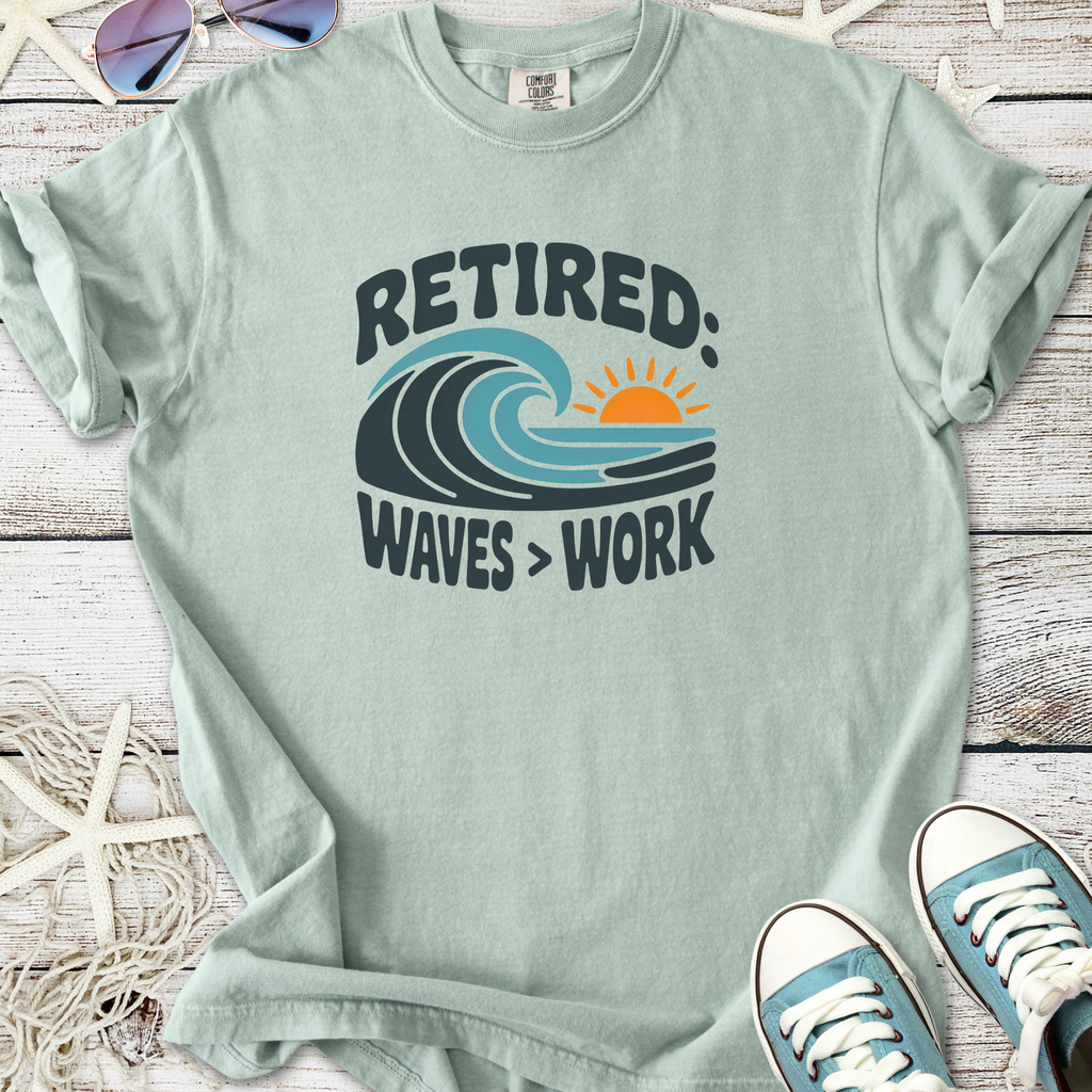 Light green cotton t-shirt with 'Retired: Waves > Work' graphic and sunset design, perfect for beach lovers.