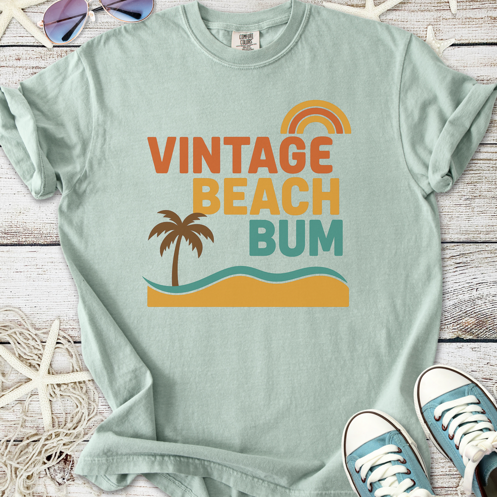 Mint green vintage beach bum t-shirt, featuring palm tree and rainbow graphic design, perfect for summer outfits.