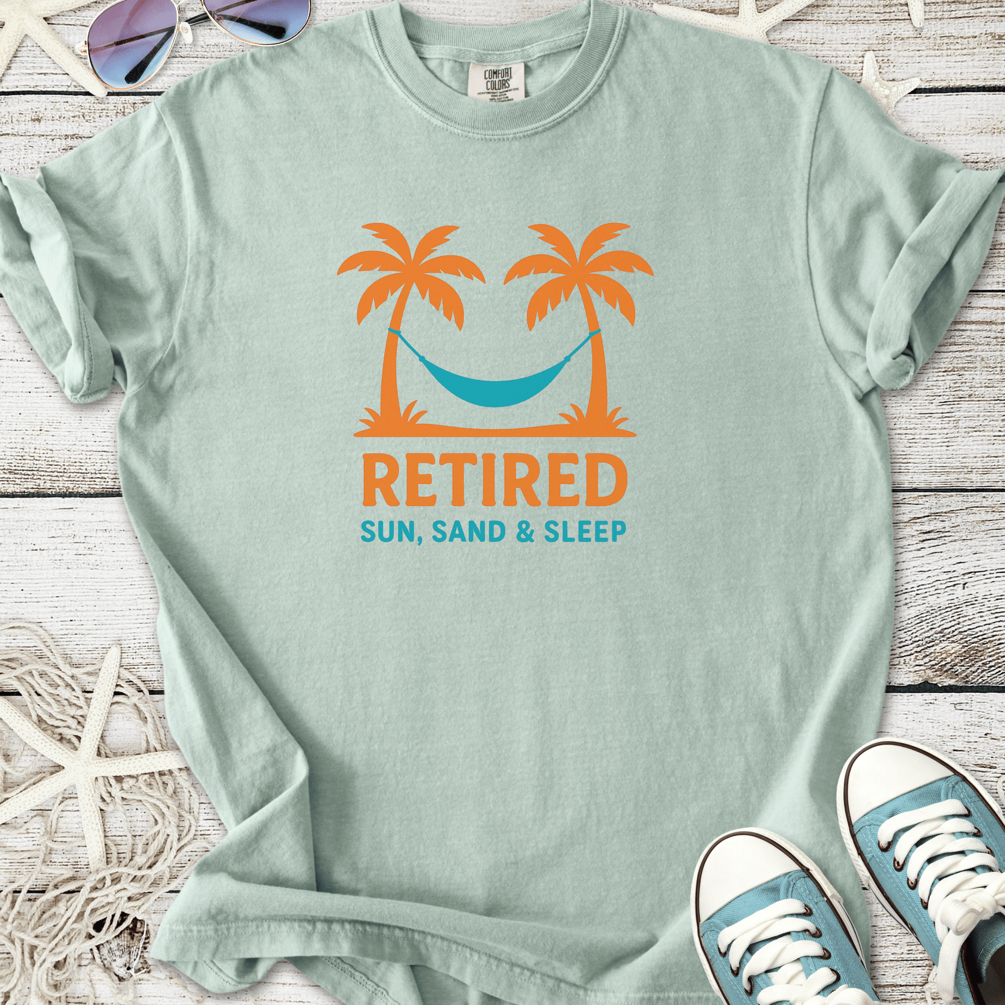 Light mint retired graphic t-shirt featuring palm trees and hammock design, perfect for beach lovers.