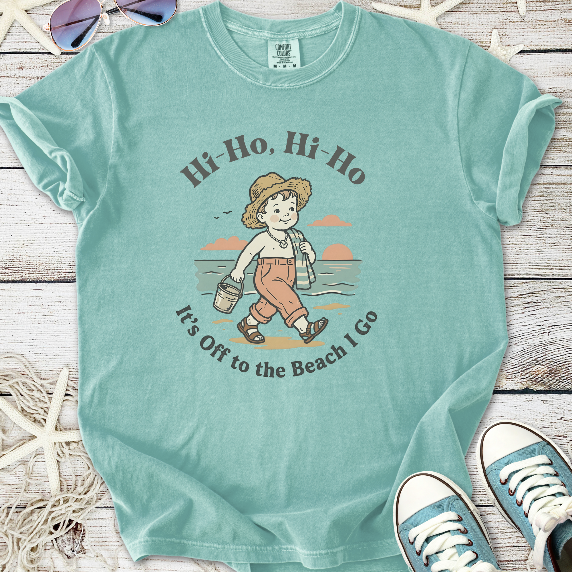 Mint green t-shirt featuring a vintage beach scene and fun text for summer adventures.