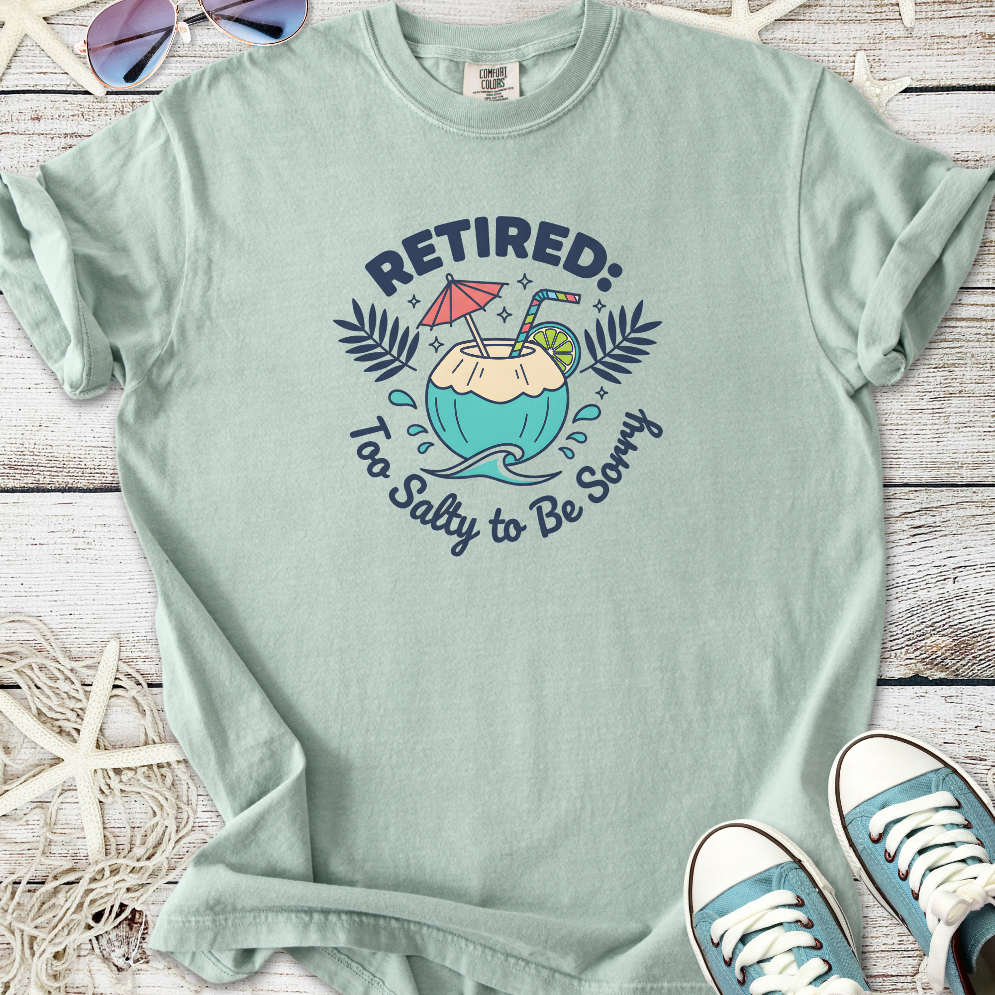 Light green t-shirt with 'Retired: Too Salty to Be Sorry' graphic, perfect for summer leisure.