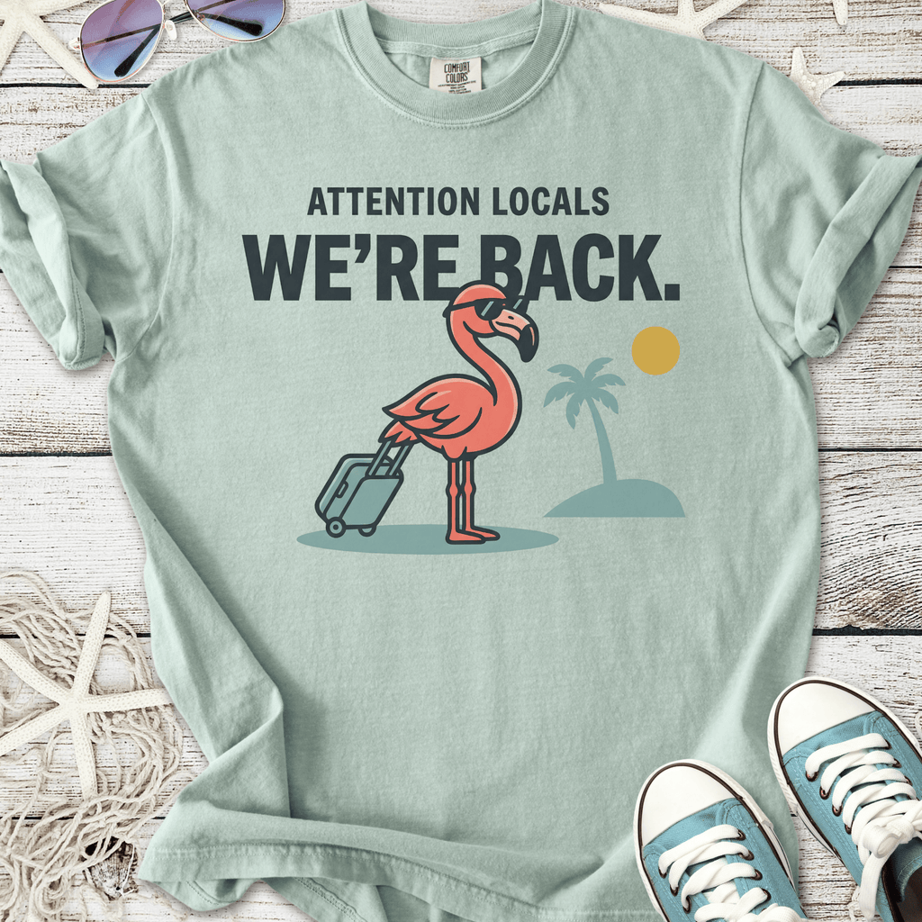 Mint green t-shirt featuring a flamingo with a suitcase and tropical design, ideal for casual wear.