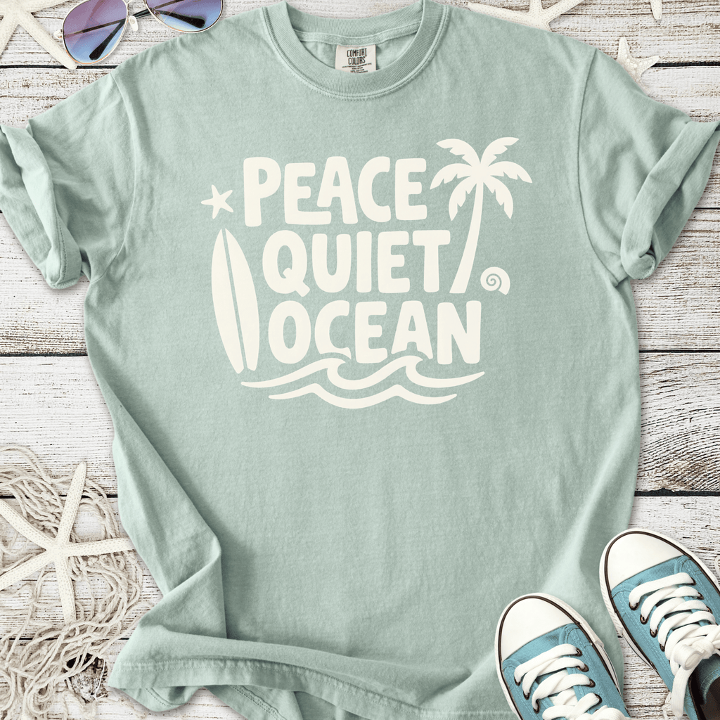 Mint green t-shirt featuring 'Peace Quiet Ocean' graphic, surfboard and palm trees, made of soft cotton.