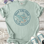 Mint green t-shirt featuring a turtle graphic for 'Slow Life Club', perfect for beach lovers.