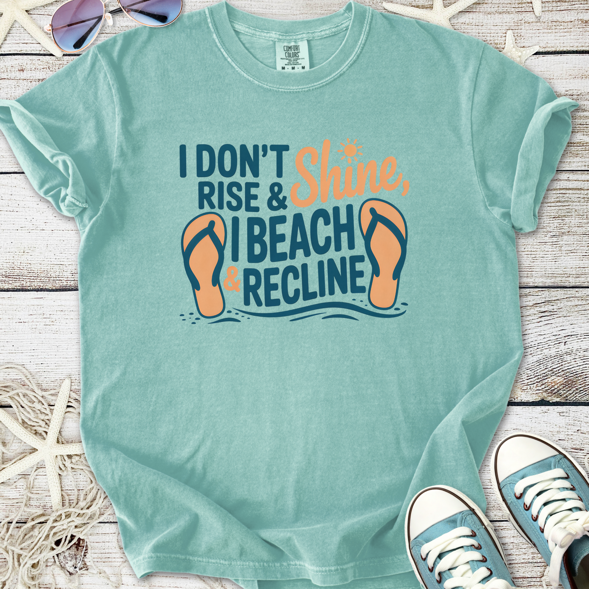 Mint green graphic tee with 'I Don't Rise & Shine, I Beach & Recline' print and flip-flop design.