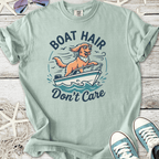 Light teal graphic tee featuring a dog on a boat with the text 'Boat Hair Don't Care', perfect for summer outings.