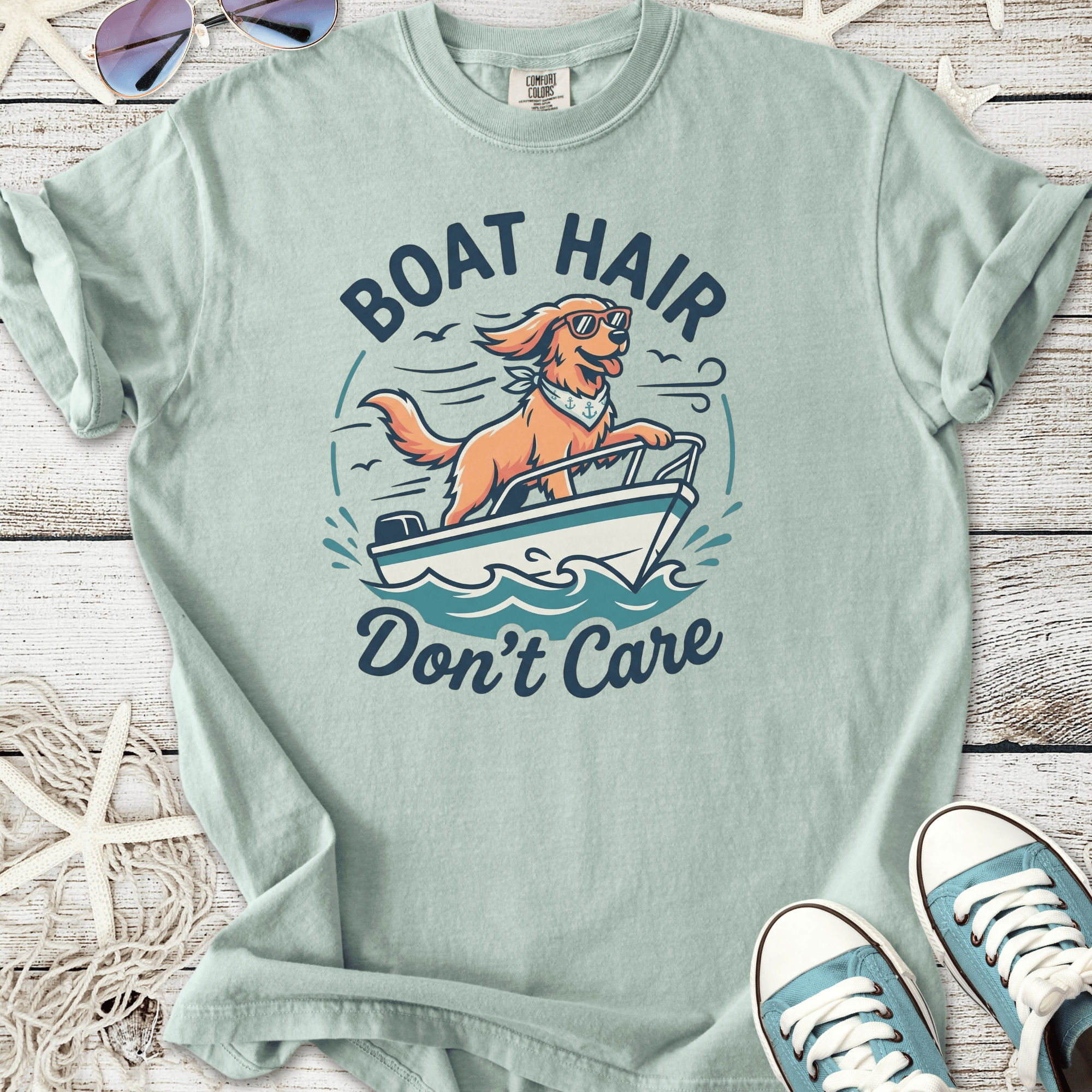 Light teal graphic tee featuring a dog on a boat with the text 'Boat Hair Don't Care', perfect for summer outings.