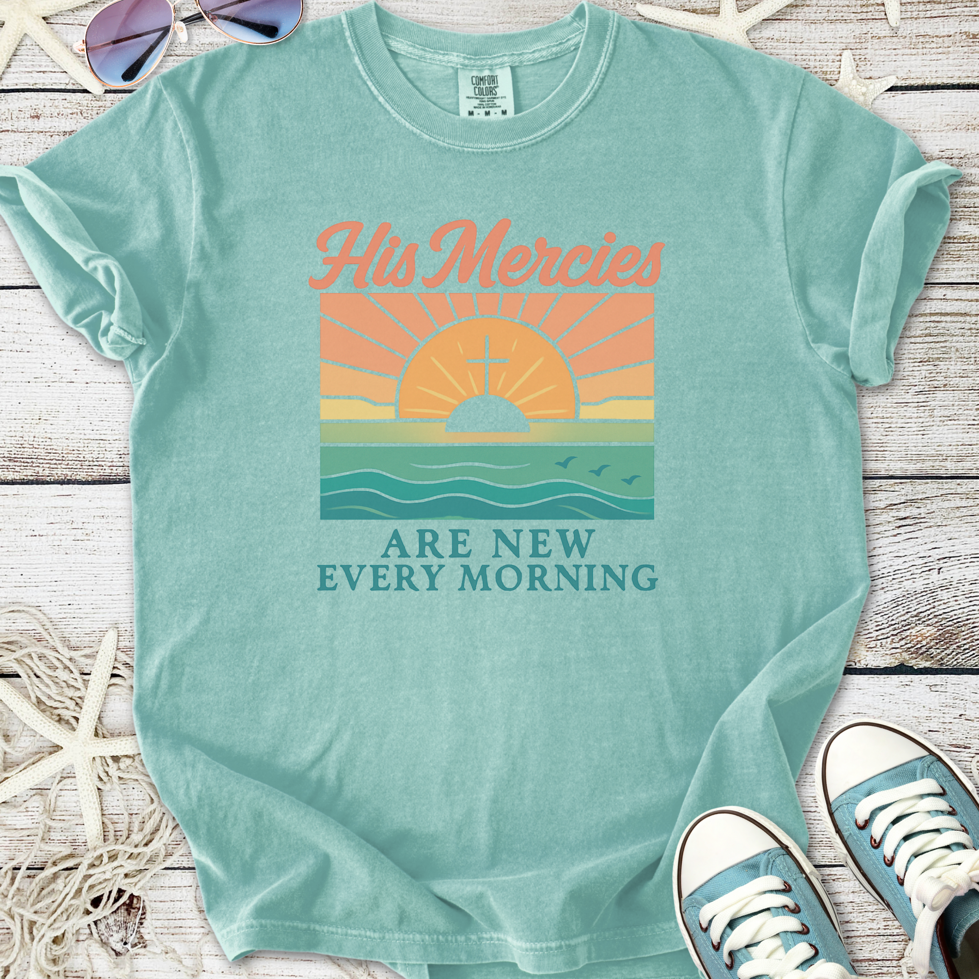 Light blue graphic t-shirt with sunrise and 'His Mercies Are New Every Morning' design, soft cotton material.