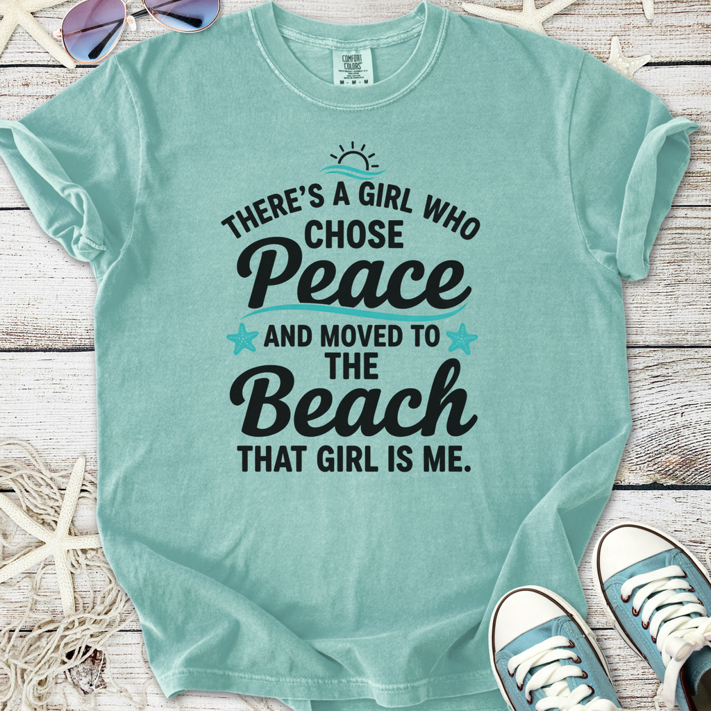 Mint green t-shirt with beach-themed graphic: 'There's a girl who chose peace and moved to the beach.'