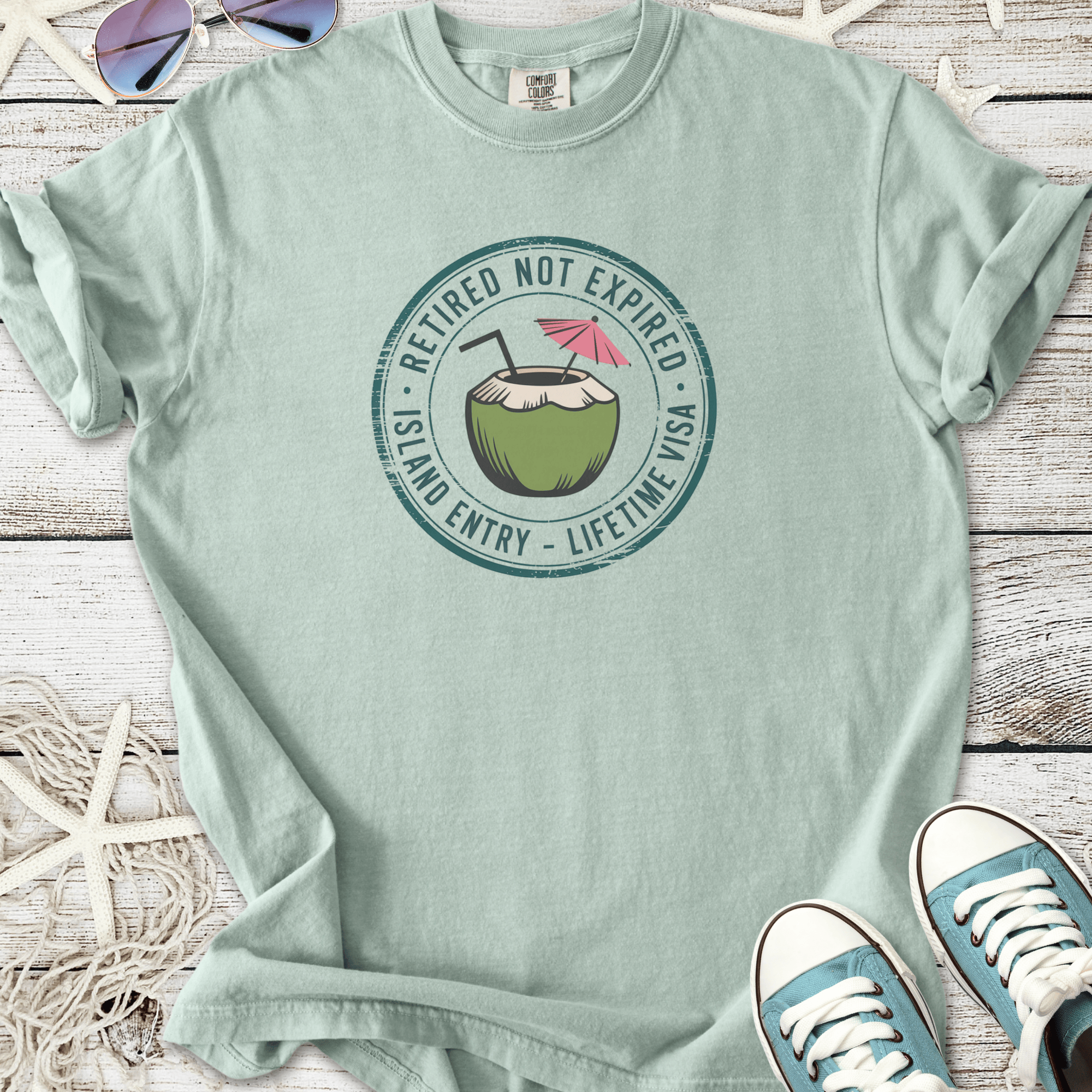 Mint green cotton t-shirt with coconut drink graphic and 'Retired Not Expired' slogan.