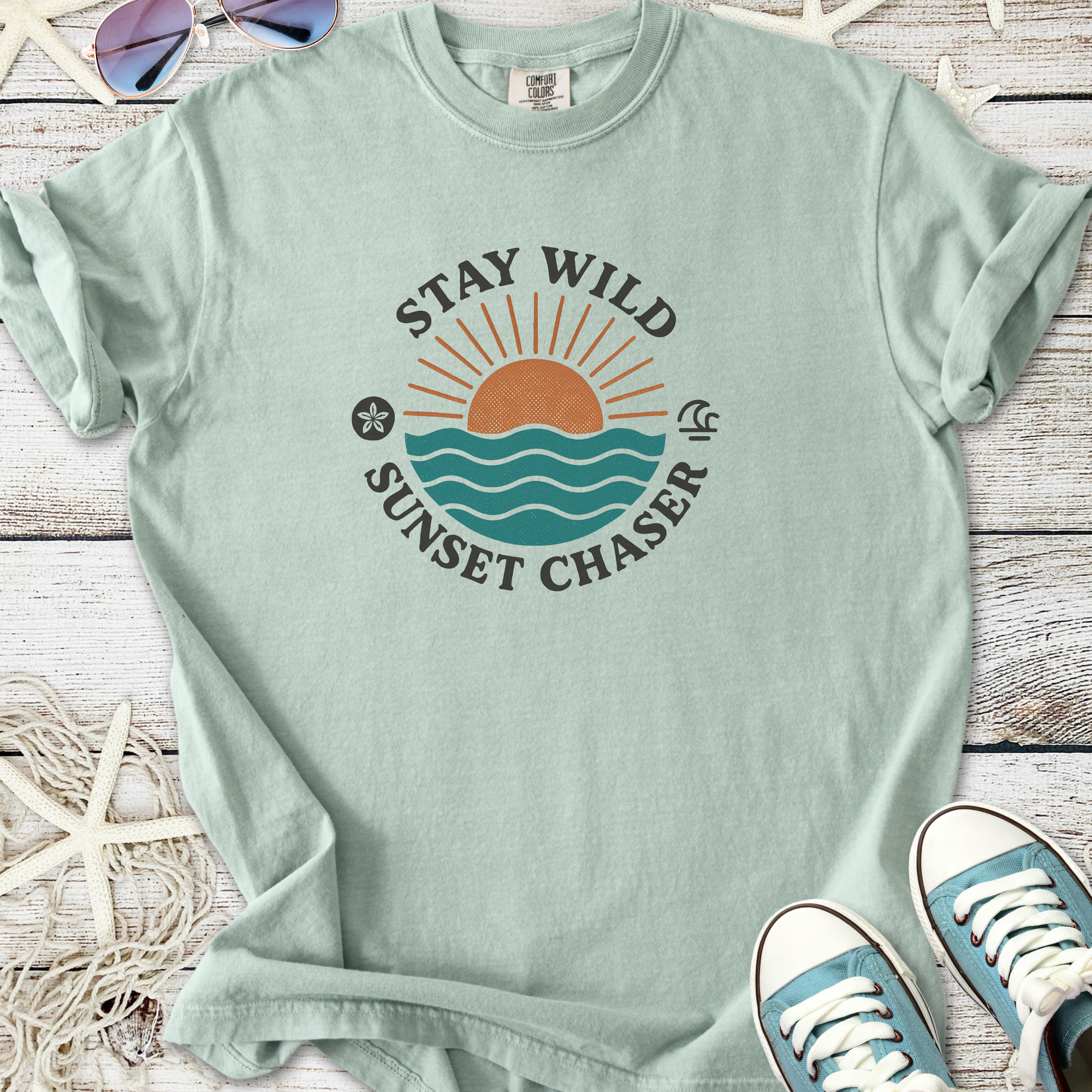 Light green graphic t-shirt with 'Stay Wild Sunset Chaser' design, perfect for casual beachwear.