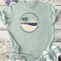 Light green graphic tee with beach-themed design featuring palm trees and sun.
