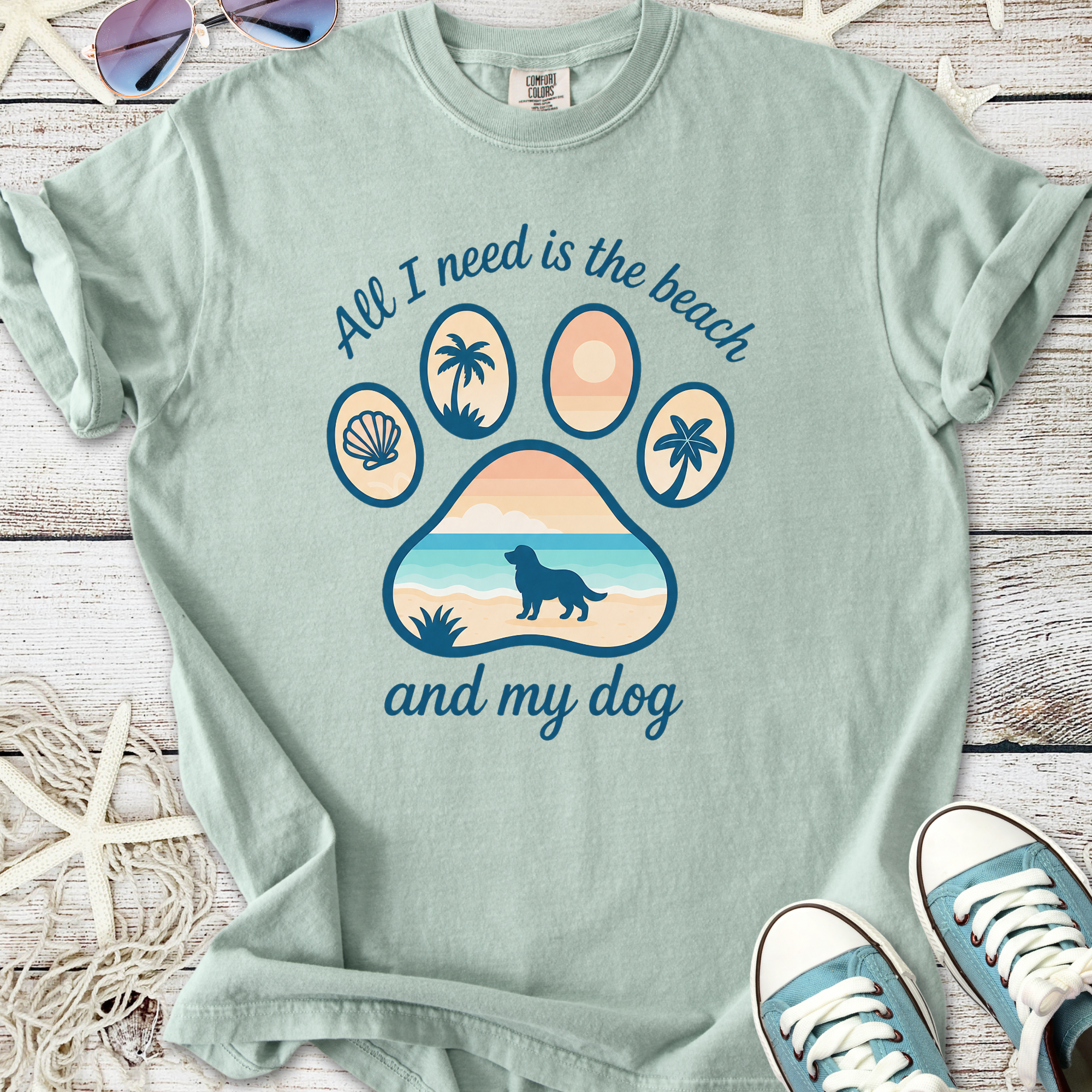 Mint green t-shirt with beach-themed paw print design, featuring a dog silhouette and tropical elements.