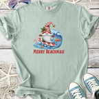 Light blue t-shirt featuring a surfing Santa graphic with 'Merry Beachmas!' text, perfect for holiday beach vibes.