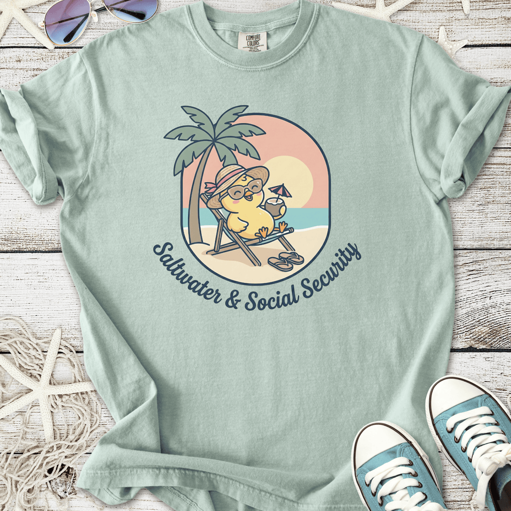 Light blue tee featuring a cute chick in sunglasses, relaxing under a palm tree with the phrase 'Saltwater & Social Security'.
