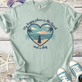 Mint green t-shirt featuring a beach graphic and dog, perfect for casual summer wear.