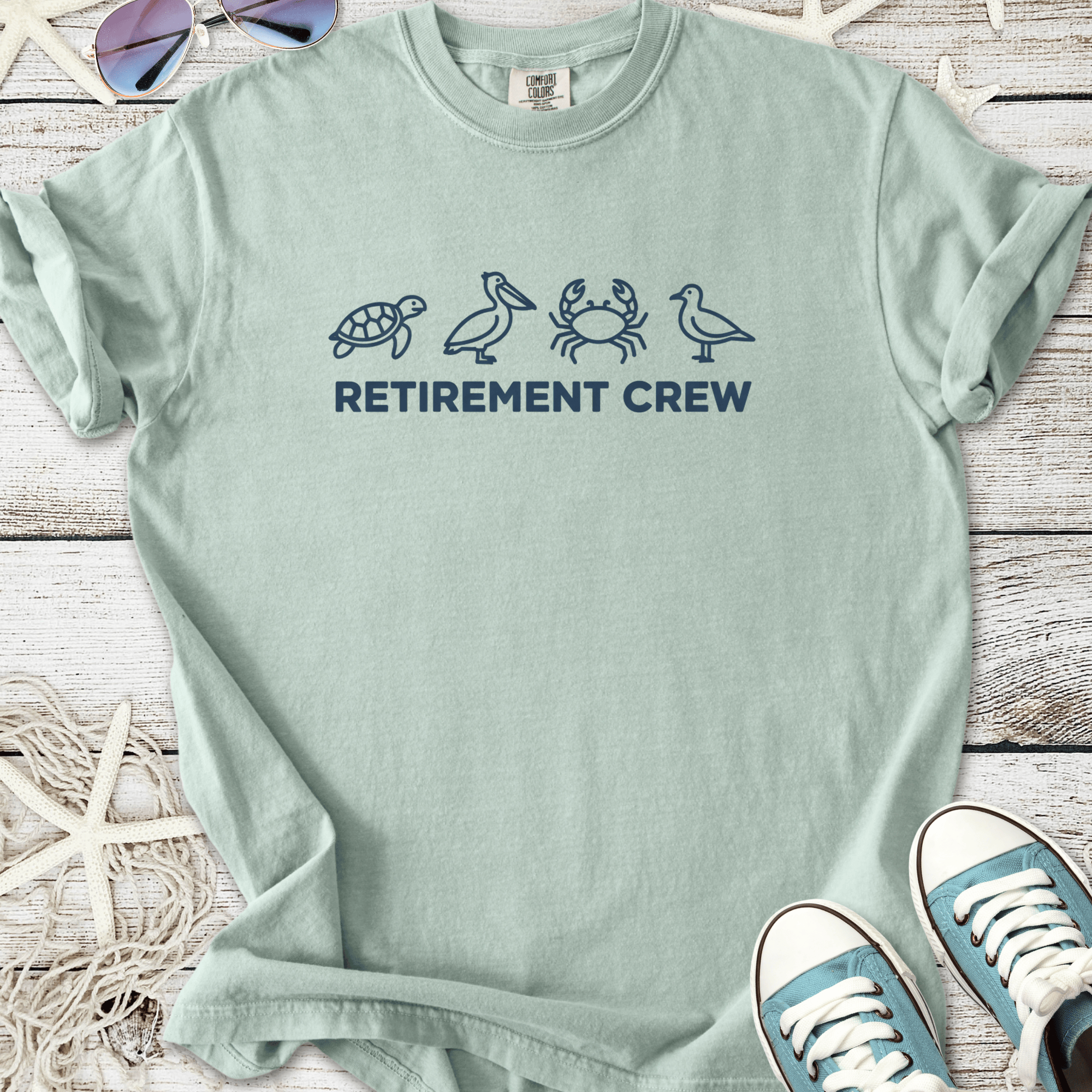 Light green retirement crew t-shirt featuring marine life graphics: turtle, pelican, crab, and bird.