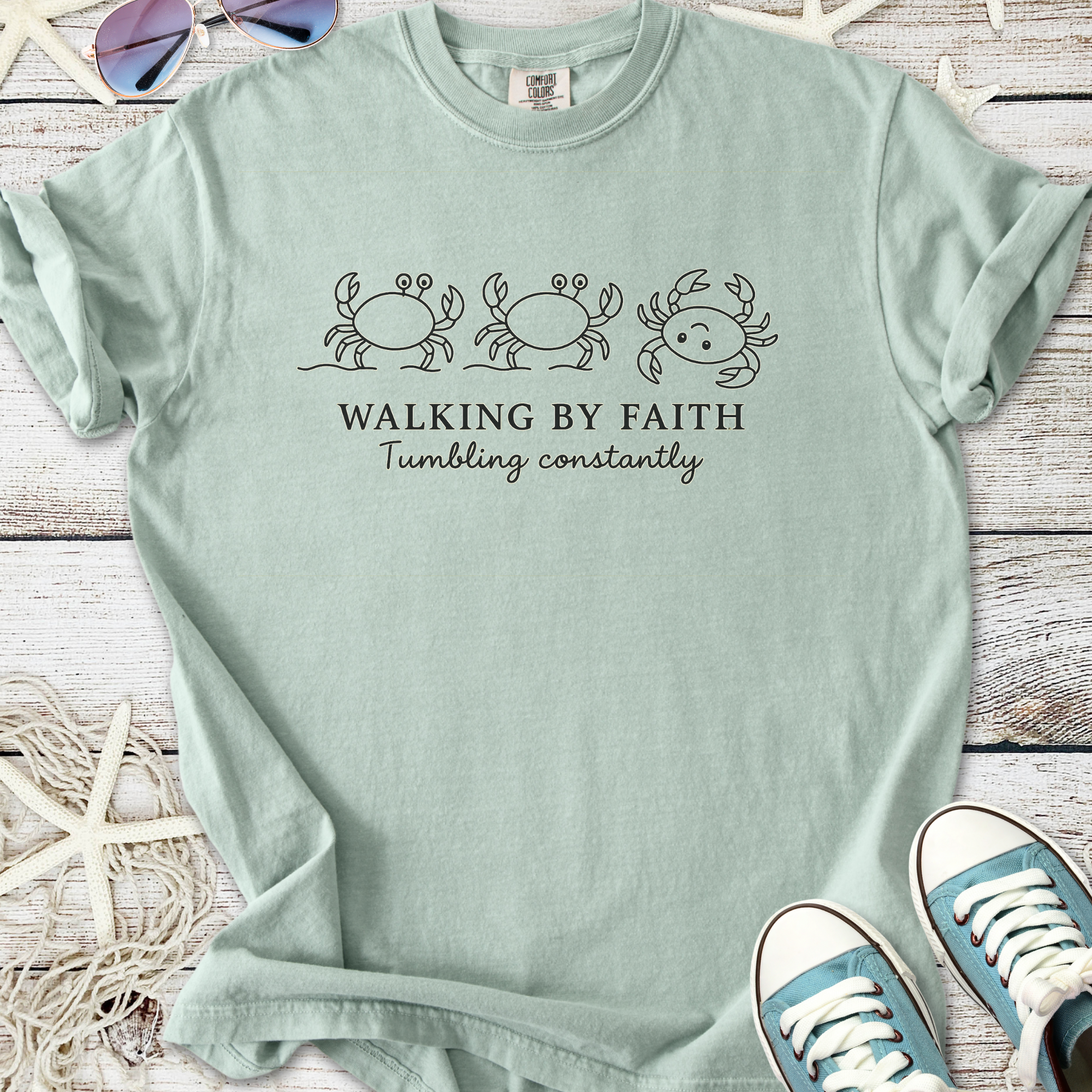 Seafoam green t-shirt with crab graphics and 'Walking by Faith' text, made from soft cotton.