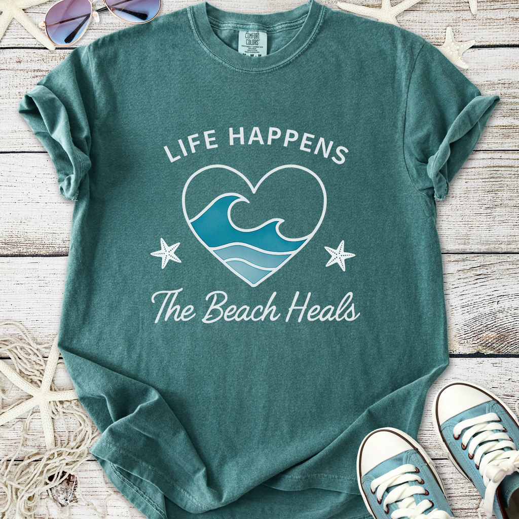 Teal beach-themed t-shirt with 'Life Happens The Beach Heals' graphic and starfish design.