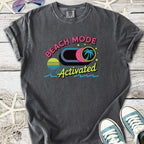 Gray graphic t-shirt featuring 'Beach Mode Activated' design with palm trees and sunset graphics.