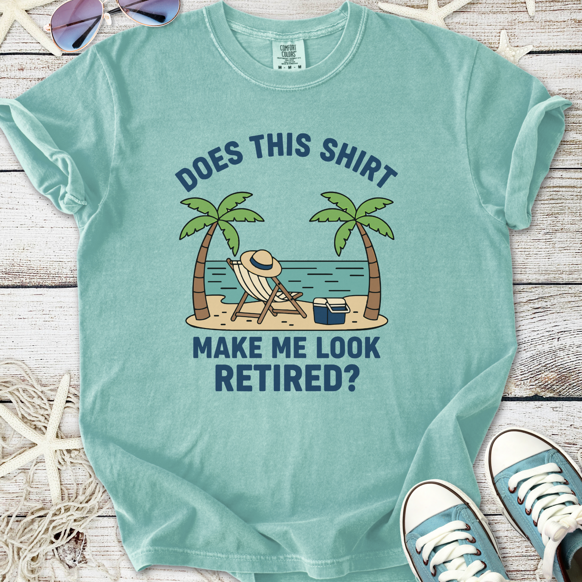 Light blue graphic t-shirt with palm tree and beach scene, text: 'Does this shirt make me look retired?'