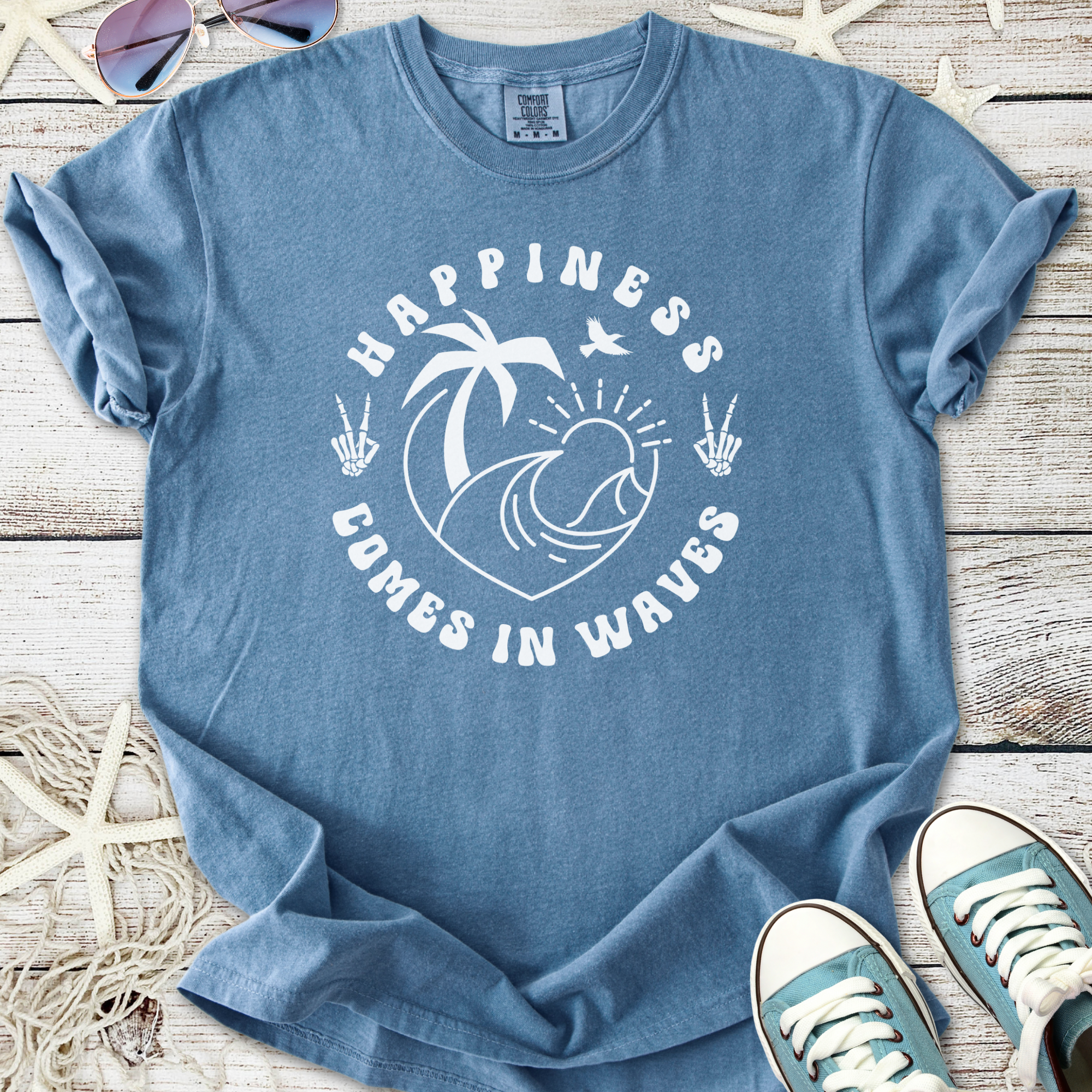 Men's blue t-shirt with 'Happiness Comes in Waves' graphic, made of soft cotton for casual beachwear.
