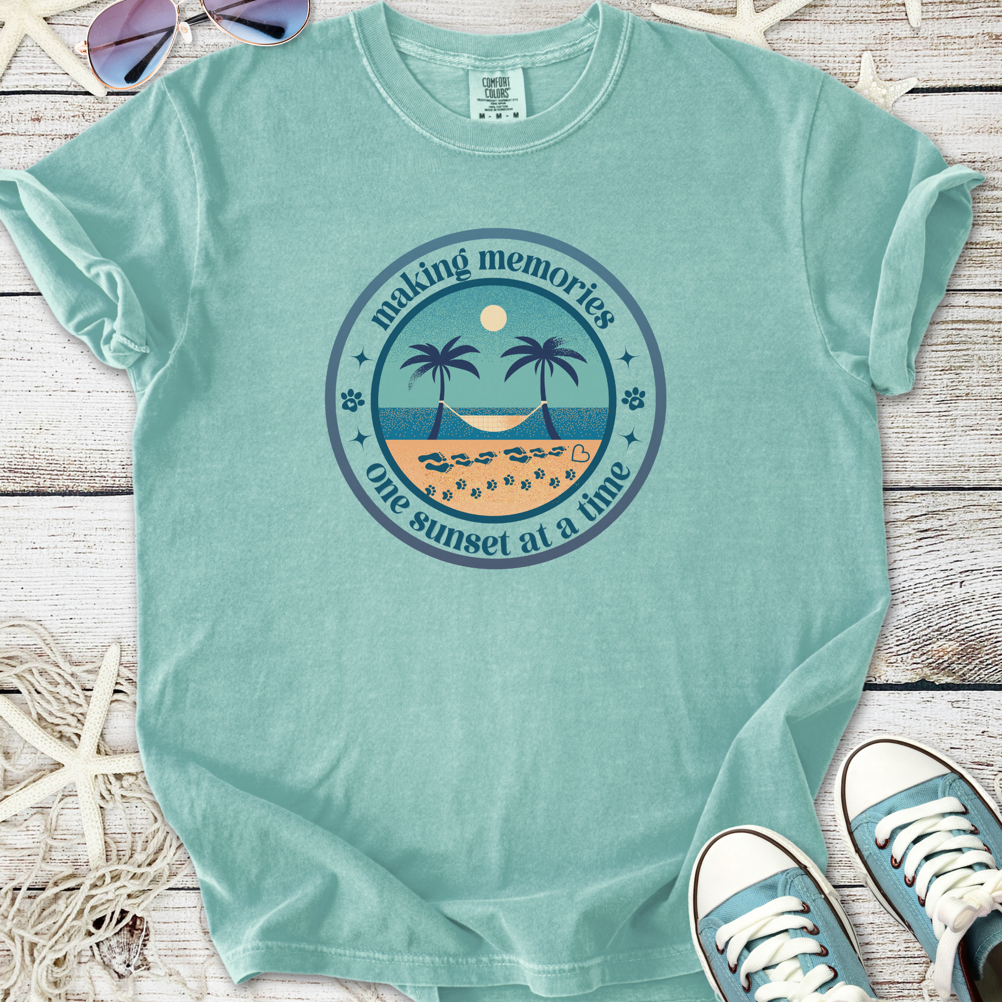 Light blue graphic tee featuring beach sunset design, palm trees, and 'making memories' text.