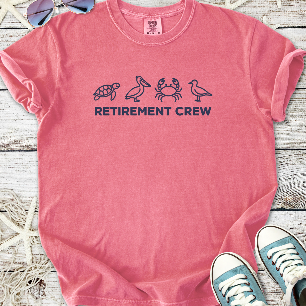 Pink cotton t-shirt with 'Retirement Crew' graphic and beach-themed icons, perfect for relaxed outings.
