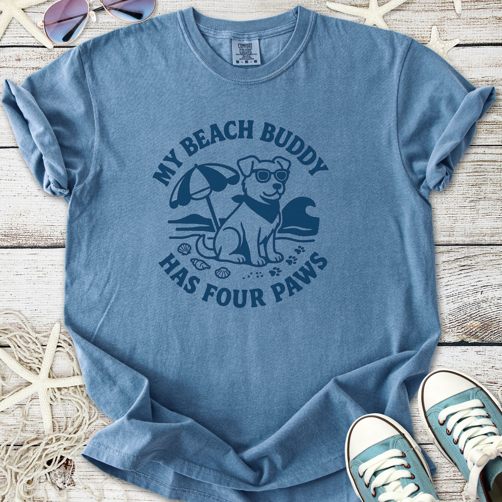 Blue graphic t-shirt featuring a dog at the beach, saying 'My Beach Buddy Has Four Paws'.