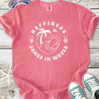 Pink graphic t-shirt featuring 'Happiness Comes in Waves' design, made of soft cotton.