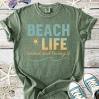 Olive green t-shirt with 'BEACH LIFE' print, perfect for retirees, made from soft, comfortable material.
