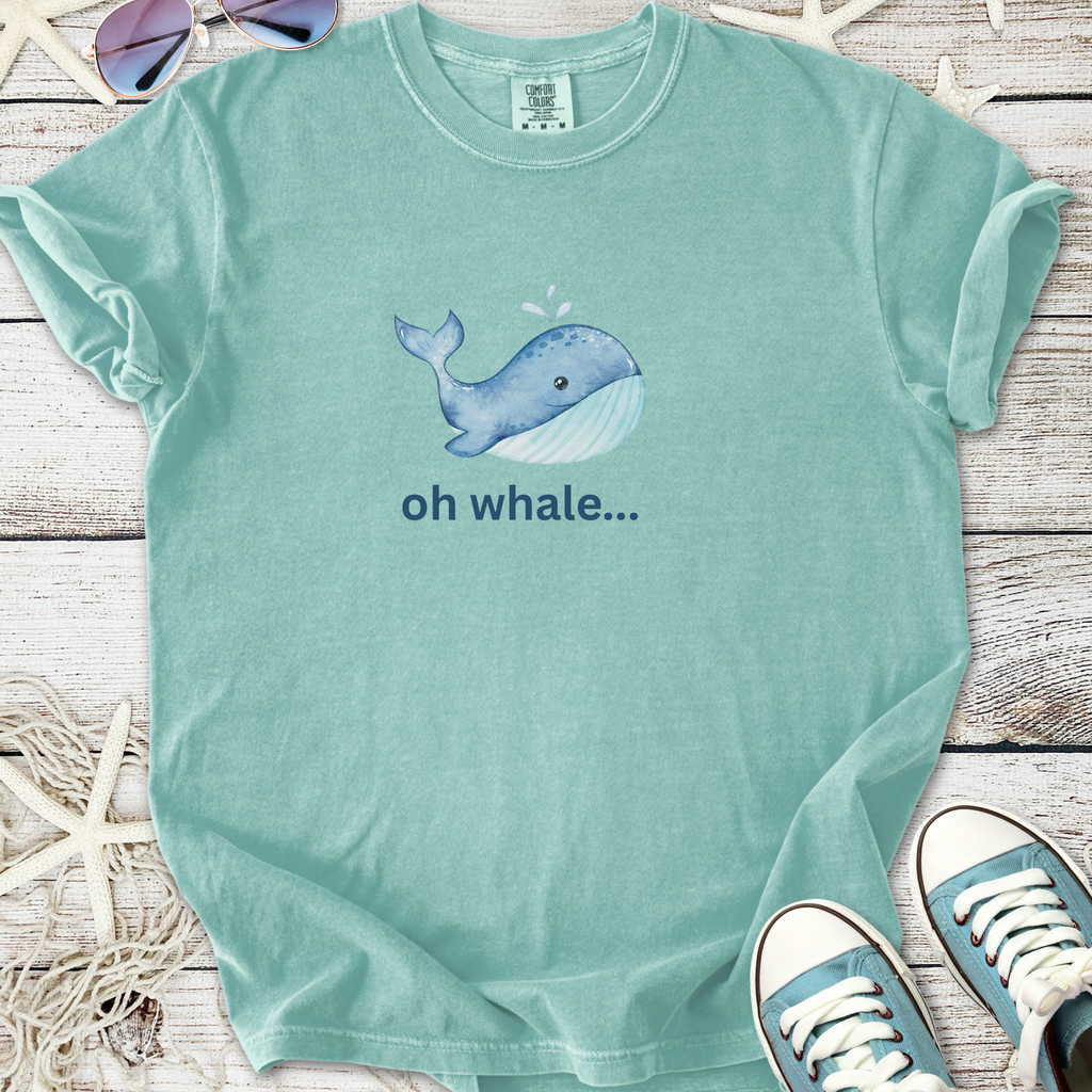 Light teal graphic tee featuring a playful whale illustration and the text 'oh whale...'