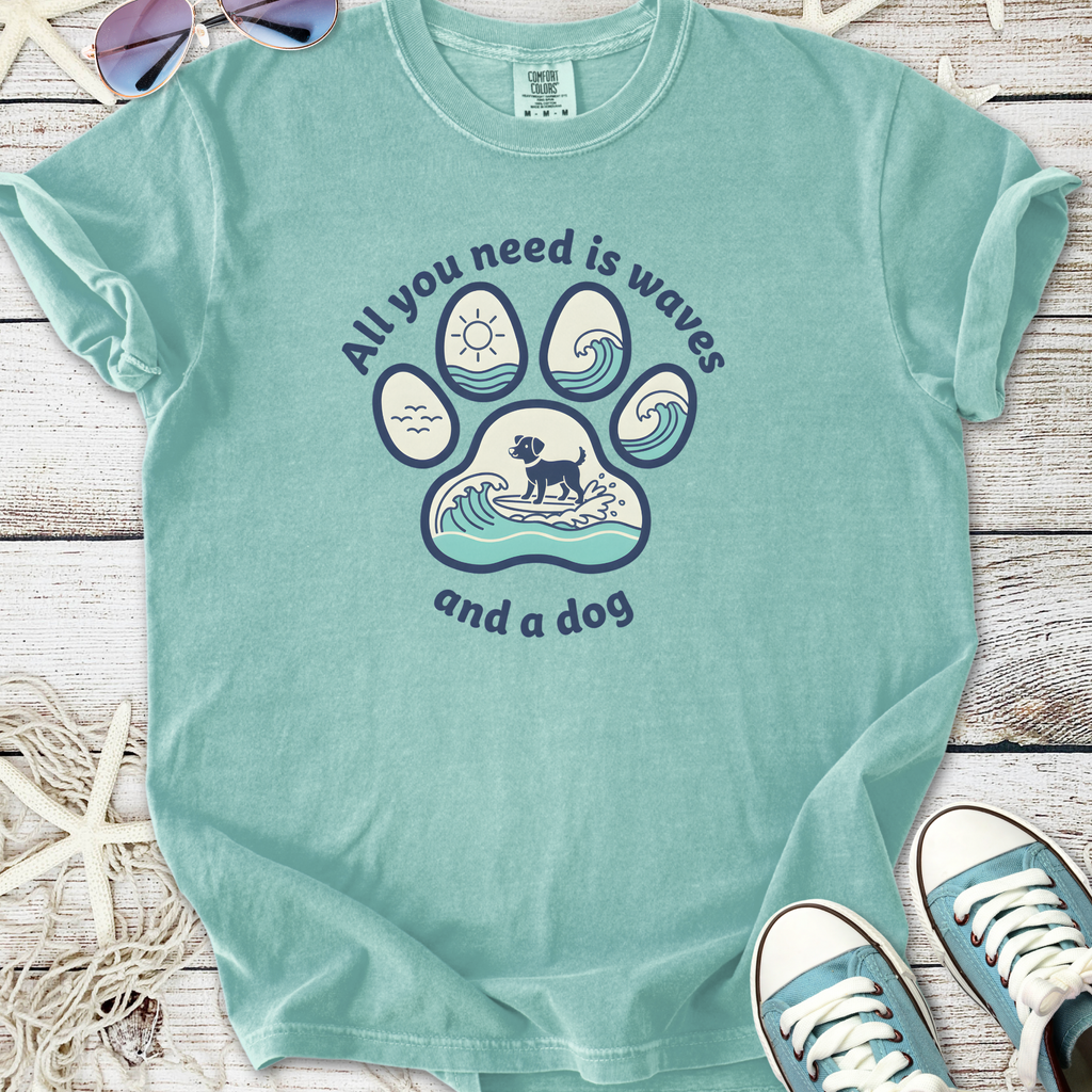 Light teal t-shirt featuring a dog paw print design with waves, text: 'All you need is waves and a dog'.