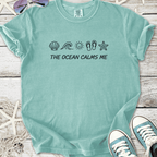 Light blue t-shirt with 'THE OCEAN CALMS ME' graphic and beach-themed icons, soft cotton material.