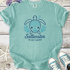 Light teal t-shirt featuring a turtle design and 'Saltwater in My Veins' text, perfect for ocean lovers.
