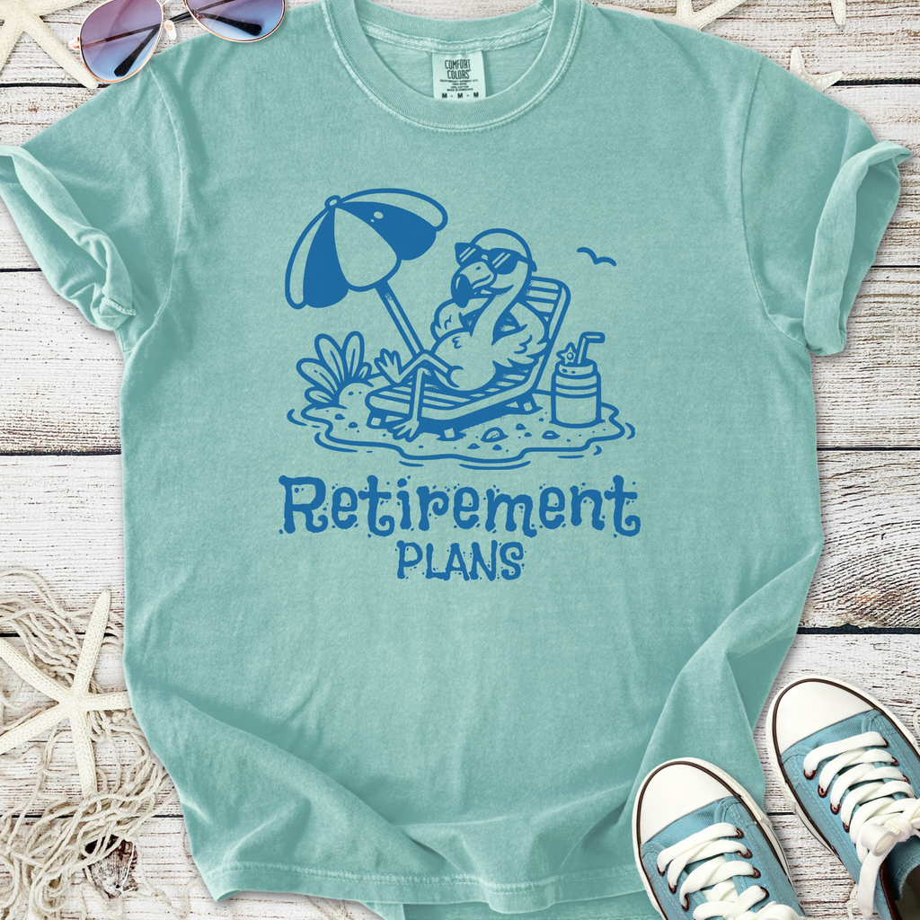 Light blue cotton t-shirt featuring a fun flamingo design with 'Retirement Plans' text, perfect for laid-back vibes.