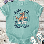 Light teal graphic t-shirt featuring a dog on a boat with the text 'Boat Hair Don't Care'.