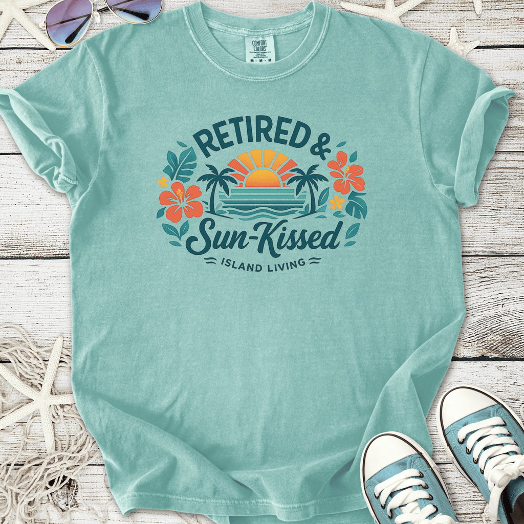 Mint green t-shirt featuring 'Retired & Sun-Kissed' design with flowers and sunset, ideal for island living.
