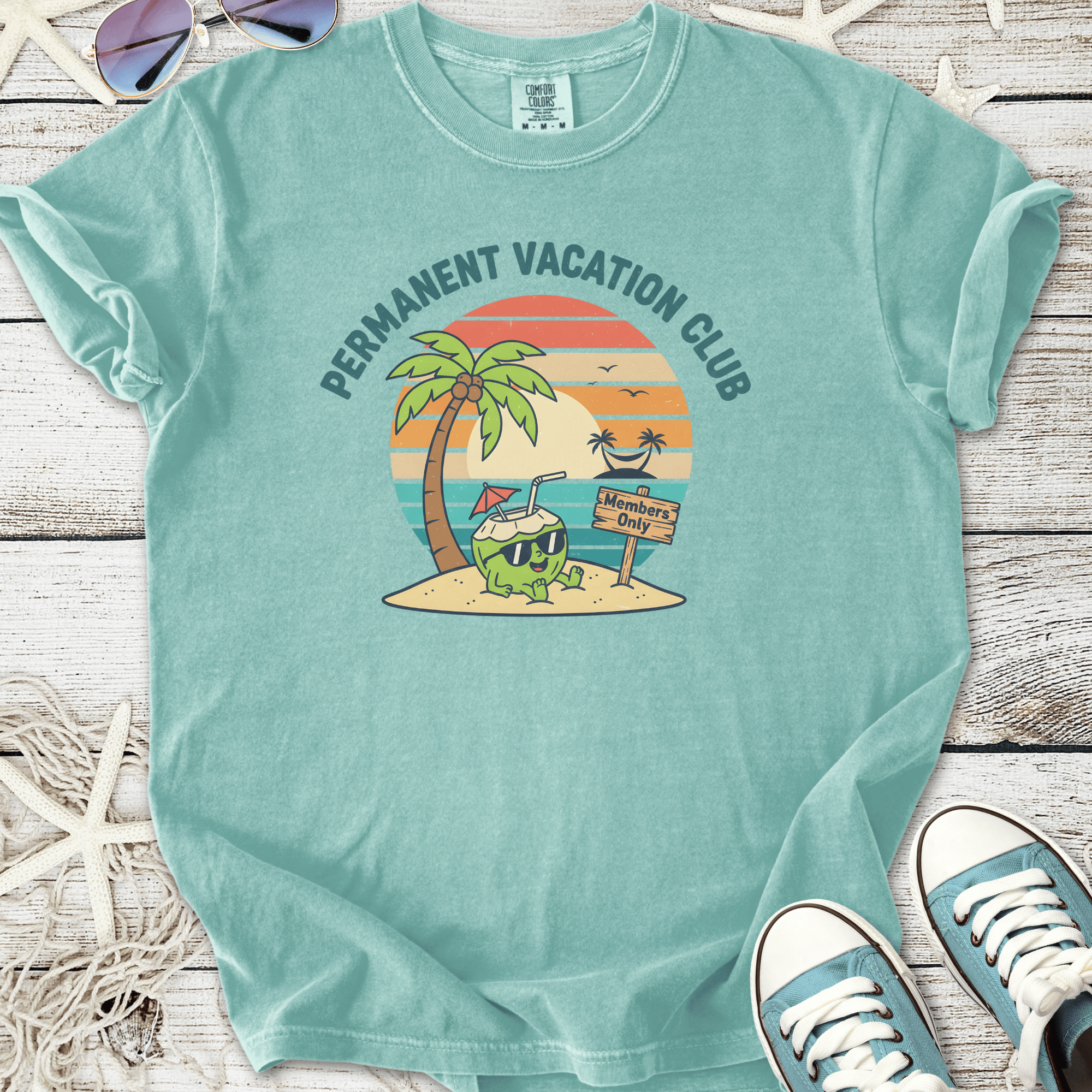 Light blue t-shirt featuring 'Permanent Vacation Club' graphic with tropical palm trees and a beach theme.