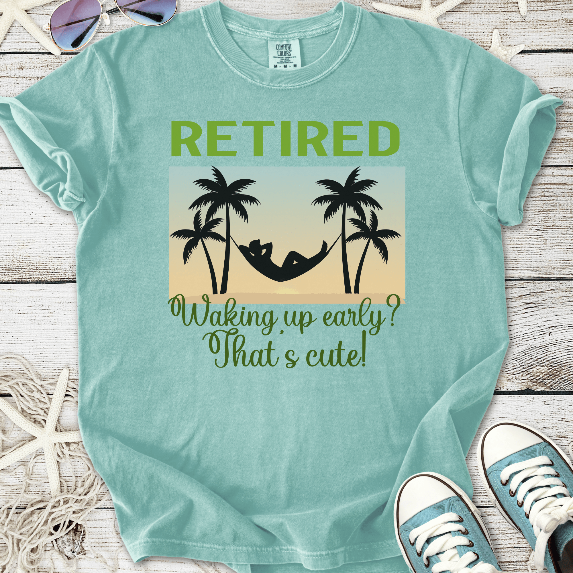 Mint green retired t-shirt with hammock and palm tree graphic, humorous retirement quote.