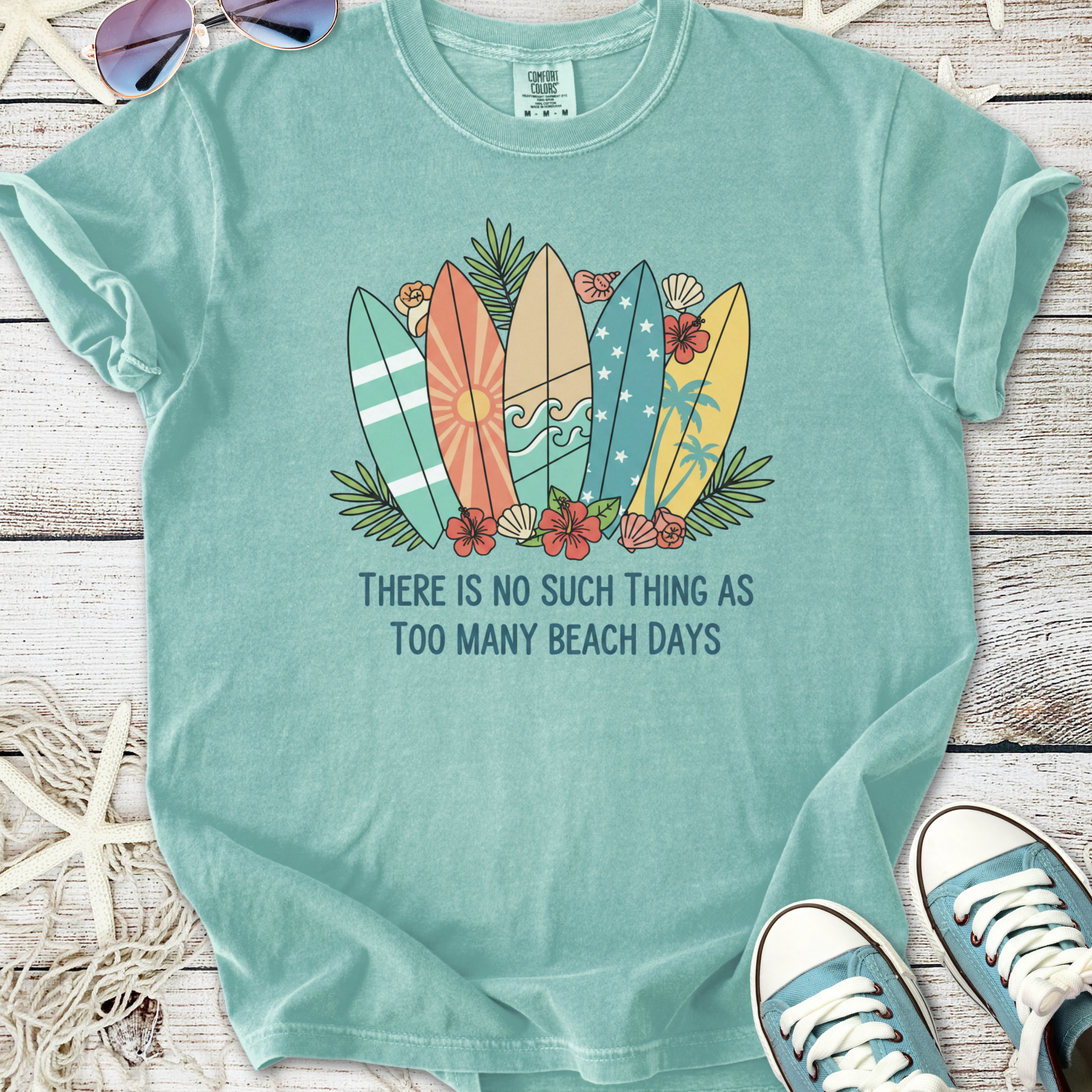 Mint green t-shirt featuring colorful surfboards and 'Too Many Beach Days' graphic, perfect for surf lovers.