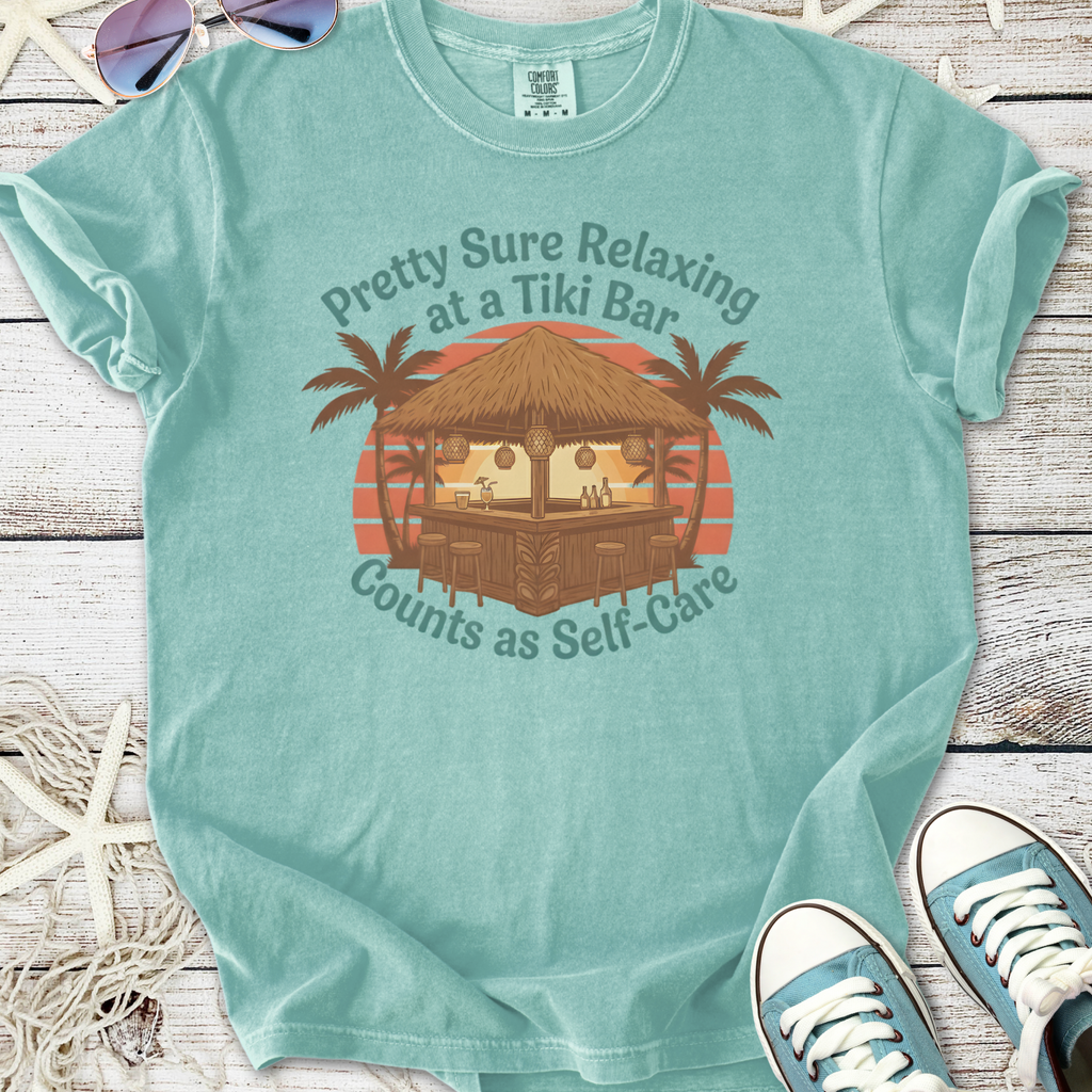 Mint green t-shirt featuring tiki bar graphic with palm trees and text about self-care.