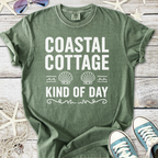 Green 'Coastal Cottage' tee, featuring seashell graphics, perfect for beach days and casual wear.