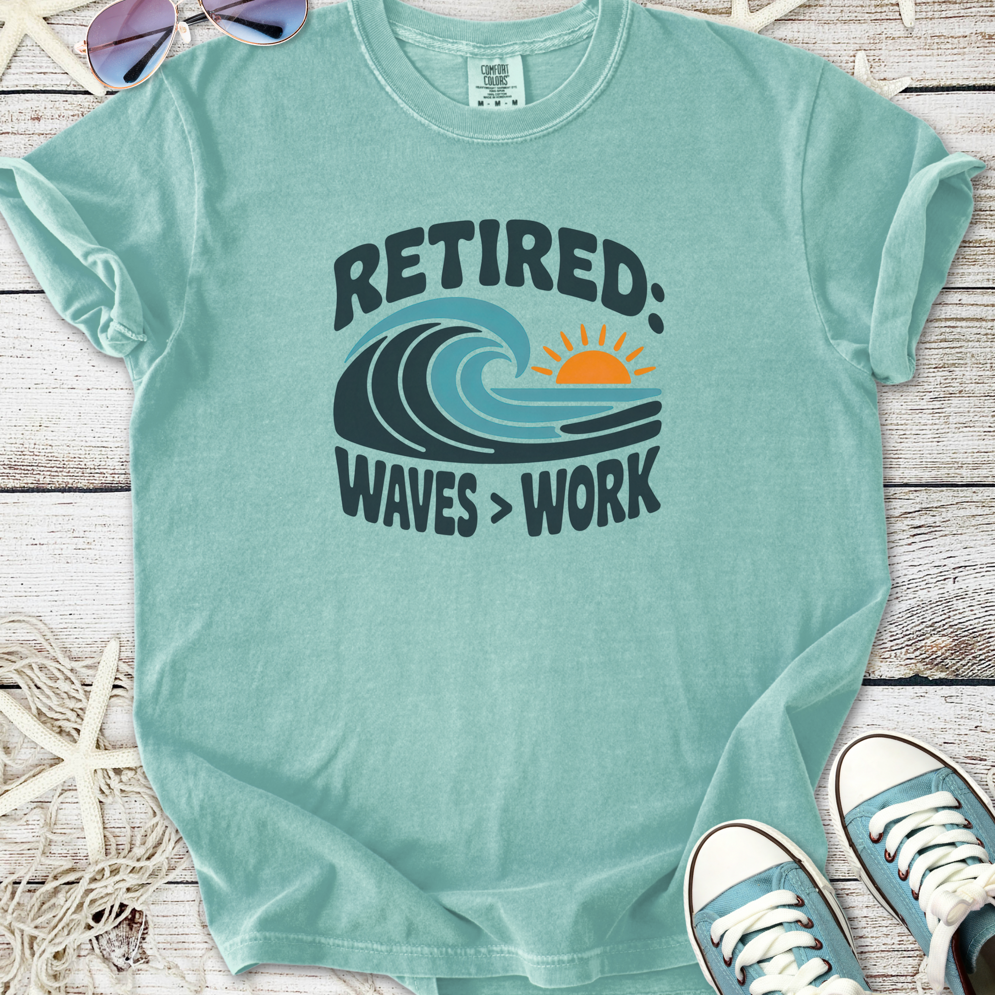 Light blue retired t-shirt with wave graphic and 'Waves > Work' text, made of soft cotton fabric.