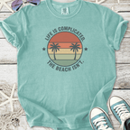 Mint green graphic t-shirt with palm trees and beach quote, perfect for casual summer wear.