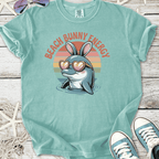 Light teal t-shirt featuring a cartoon dolphin with bunny ears and heart sunglasses, labeled 'Beach Bunny Energy'.