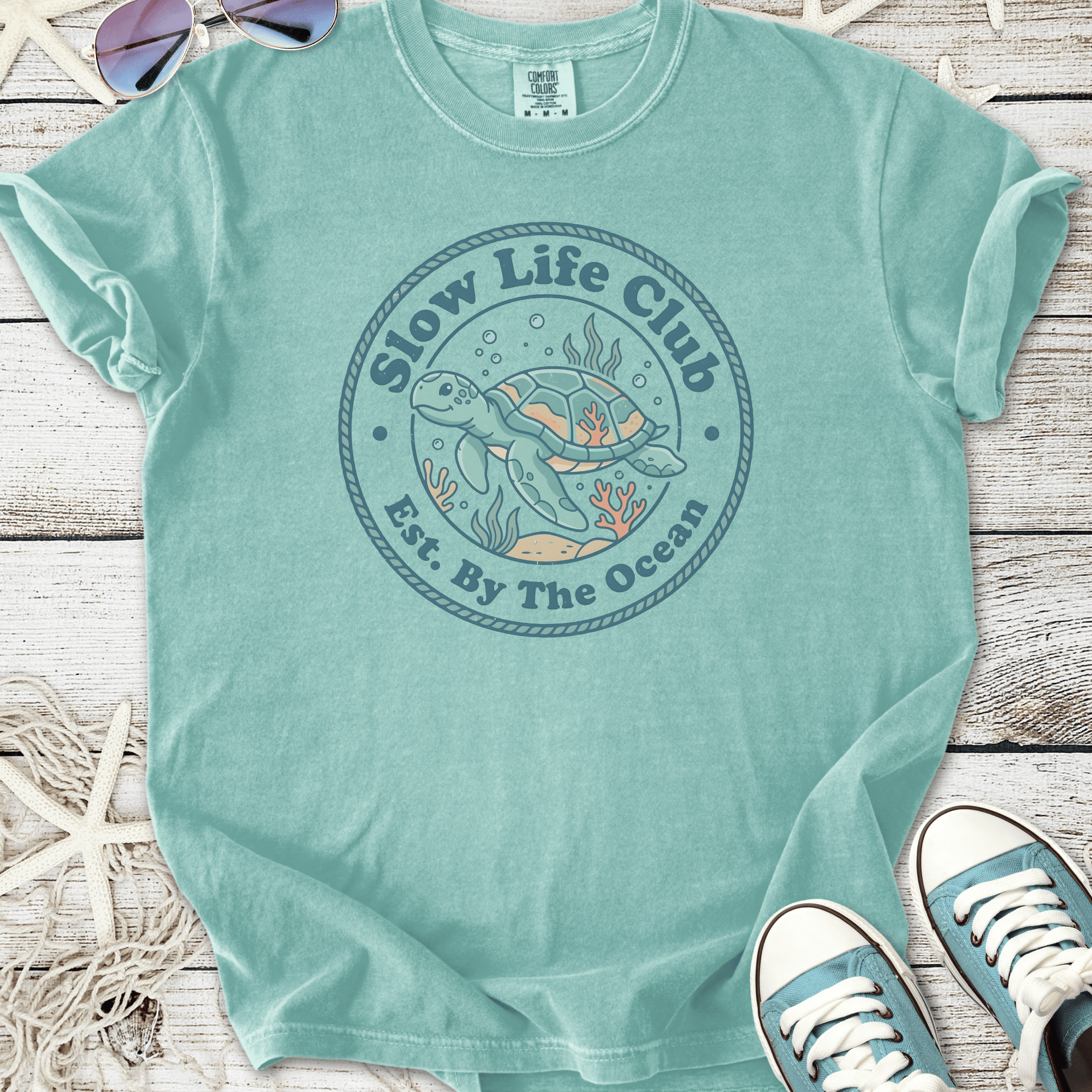 Ocean-themed turquoise t-shirt featuring 'Slow Life Club' and a turtle design, perfect for beach lovers.