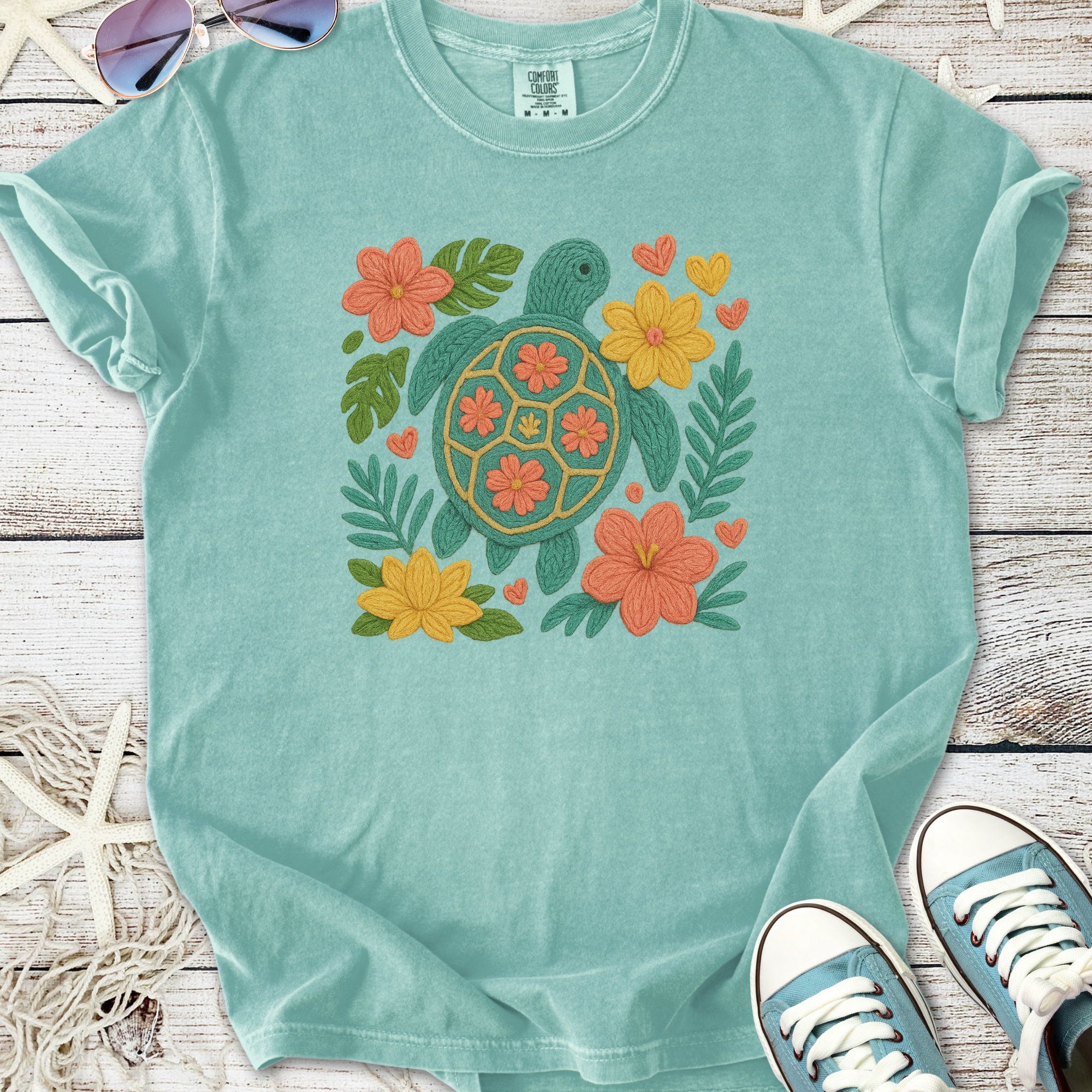 Aqua blue t-shirt featuring a colorful turtle and floral embroidery design, perfect for casual summer wear.