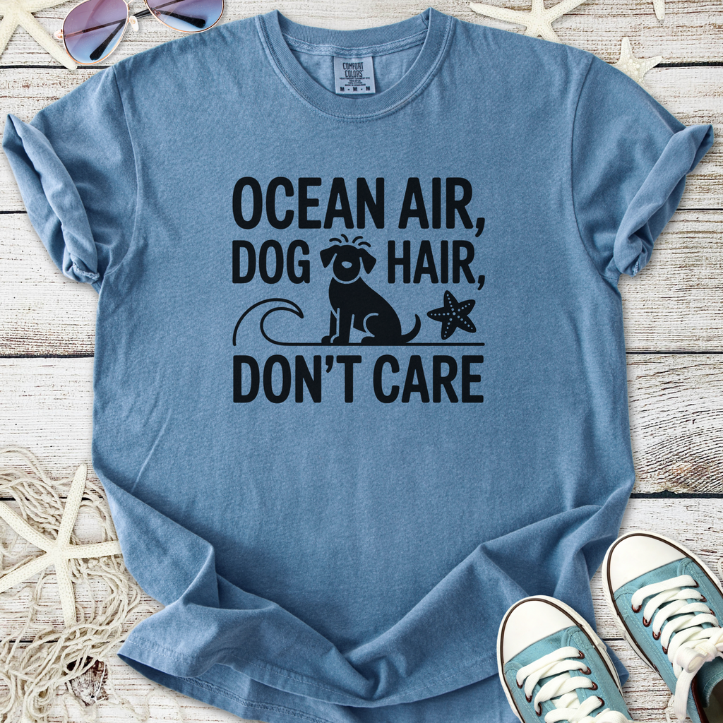 Blue graphic T-shirt with 'Ocean Air, Dog Hair, Don't Care' print, perfect for dog lovers and beach enthusiasts.